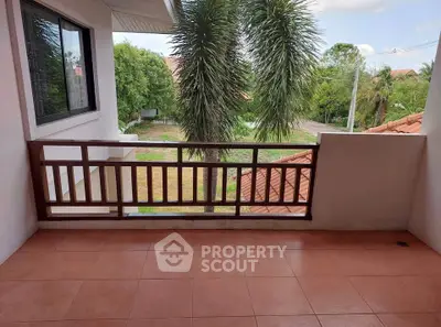 Charming balcony with scenic view of lush greenery and terracotta rooftops.