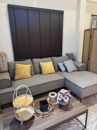 Stylish living room with modern gray sofa and decorative pillows, perfect for relaxation.