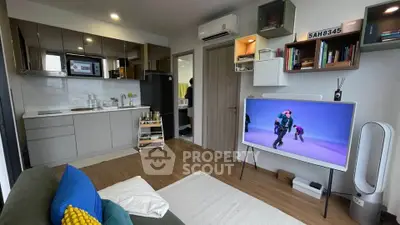 Modern living room with open kitchen, stylish decor, and smart TV setup in a cozy apartment.