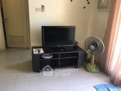 Cozy living room with TV stand and fan, perfect for relaxation.