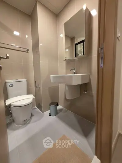 Modern bathroom with sleek fixtures and neutral tiles, perfect for a contemporary home.