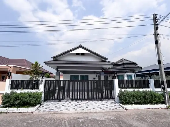 Charming single-story house with modern design and gated entrance in a serene neighborhood.