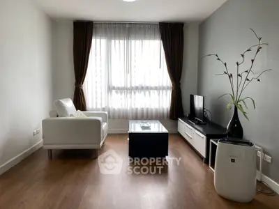 Modern living room with sleek furniture and large window, perfect for relaxation and entertainment.