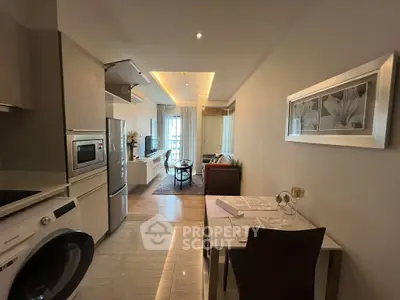 Modern open-layout kitchen and living room with stylish decor and appliances.