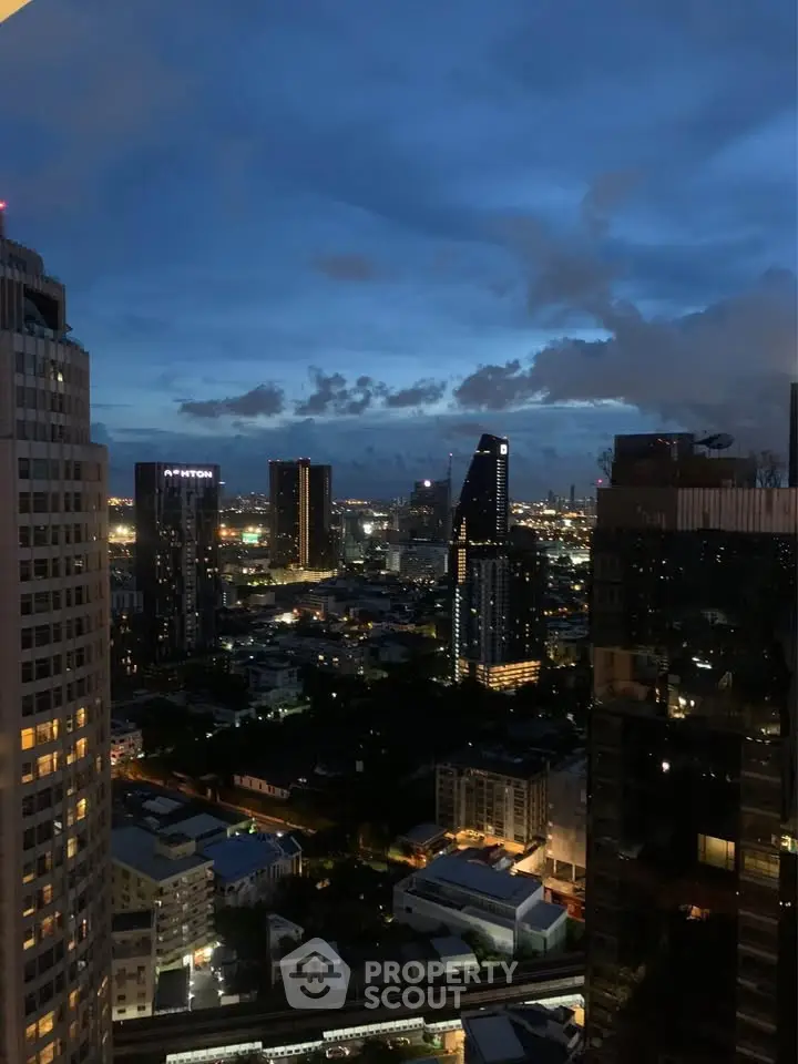 Stunning cityscape view from high-rise building at dusk with illuminated skyline.