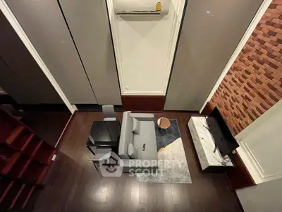 Modern living room with stylish furniture and brick accent wall