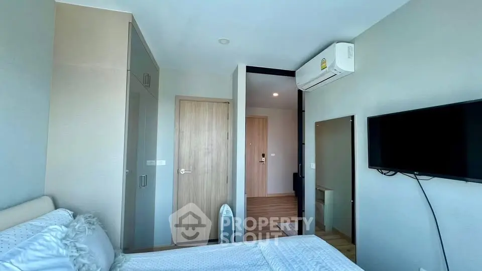 Modern bedroom with air conditioning and wall-mounted TV in a stylish apartment.