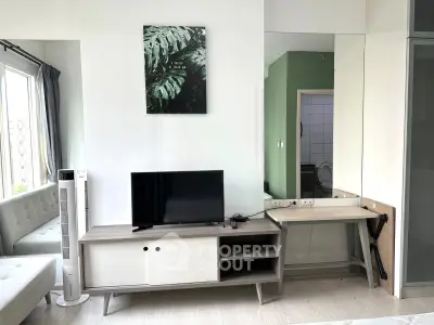 Modern living room with sleek TV stand, large mirror, and stylish decor in a bright apartment.