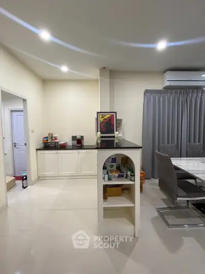 Spacious modern dining area with sleek furniture and ample lighting, perfect for family gatherings.
