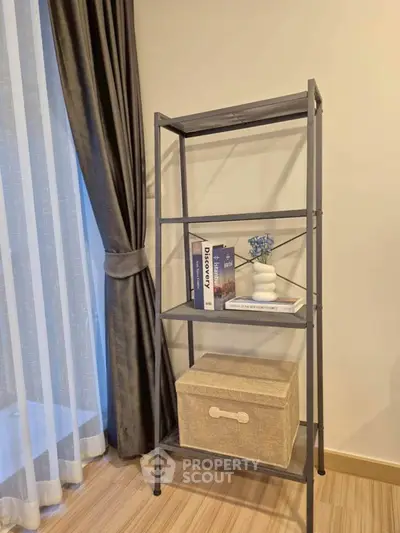 Stylish interior with modern shelving unit and elegant curtains in a cozy living space.