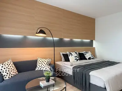 Modern bedroom with stylish decor, cozy seating area, and ambient lighting for a comfortable living experience.