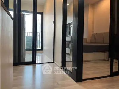 Modern apartment interior with sleek design and balcony view, featuring a cozy living area and stylish kitchen.