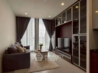 Modern living room with floor-to-ceiling windows and sleek entertainment unit.