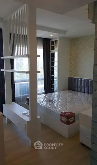 Modern bedroom with stylish partition and large window for natural light.