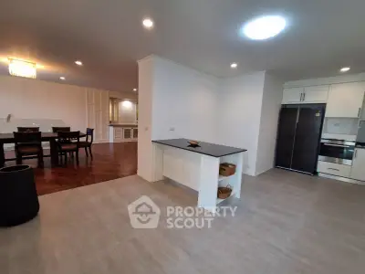 Spacious open-plan kitchen and dining area with modern appliances and elegant lighting.