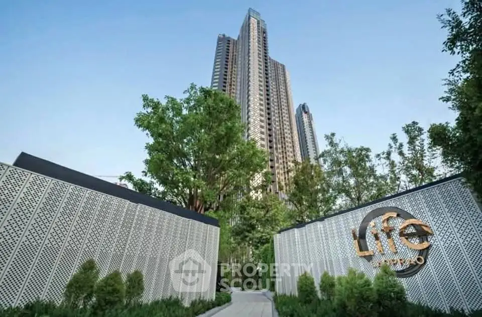 Stunning high-rise building with lush greenery at Life Asoke Hype entrance.
