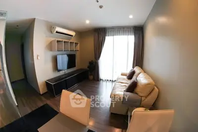Modern living room with cozy sofa and wall-mounted TV, featuring elegant lighting and stylish decor.