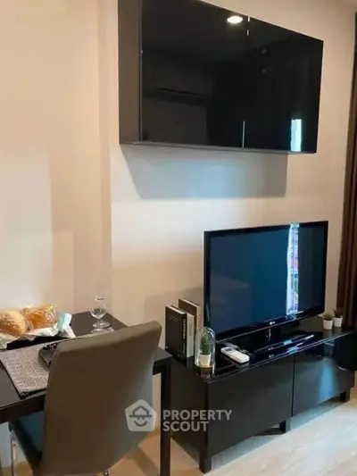Modern living room with sleek black furniture and wall-mounted TV