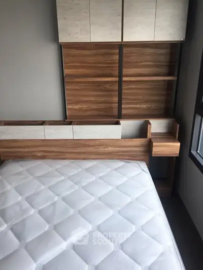 Modern bedroom with sleek wooden storage and comfortable mattress, perfect for urban living.