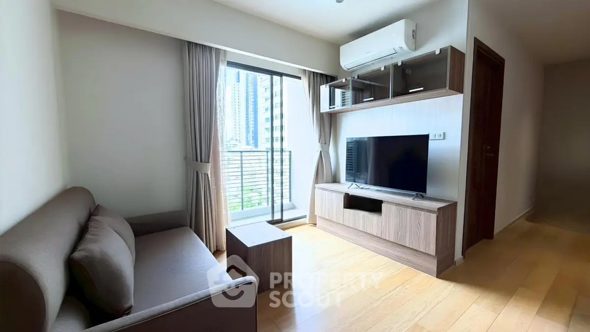 Modern living room with balcony view, featuring sleek furniture and natural light.