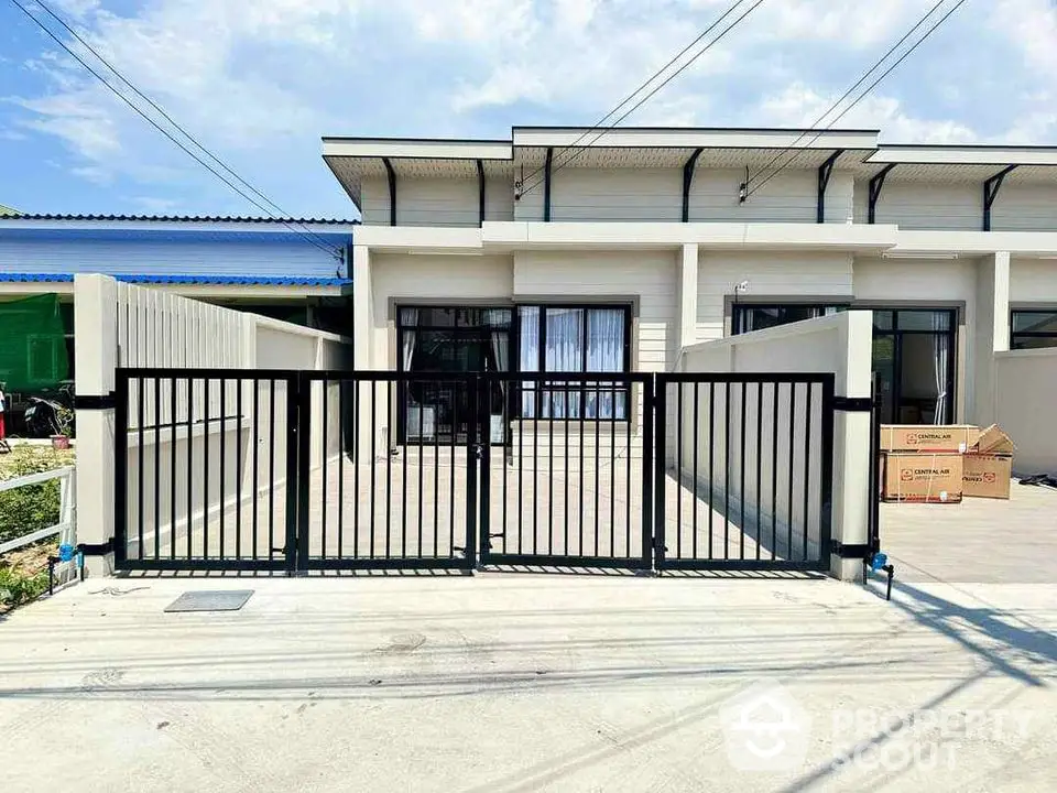 Modern townhouse exterior with gated entrance and spacious driveway