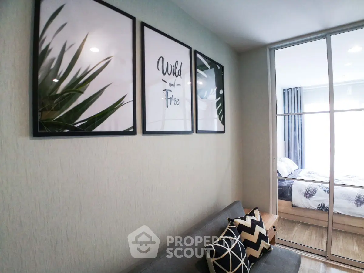 Modern living room with stylish decor and view into cozy bedroom