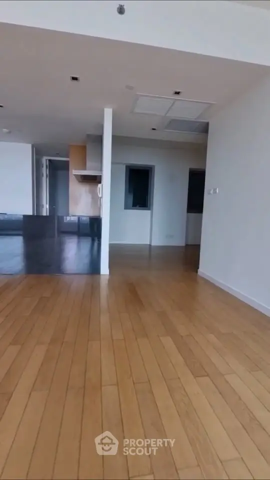 Spacious open-plan living area with wooden flooring and modern design.