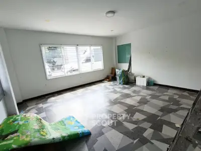 Spacious unfurnished room with large window and tiled floor, ideal for customization.