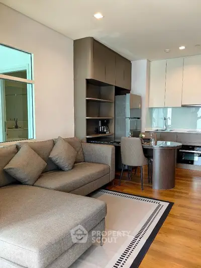 Modern open layout living room with sleek kitchen and cozy seating area.
