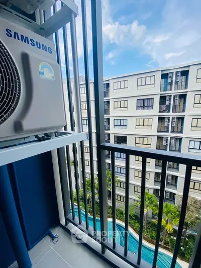 Modern balcony view with pool and residential buildings, perfect for urban living.