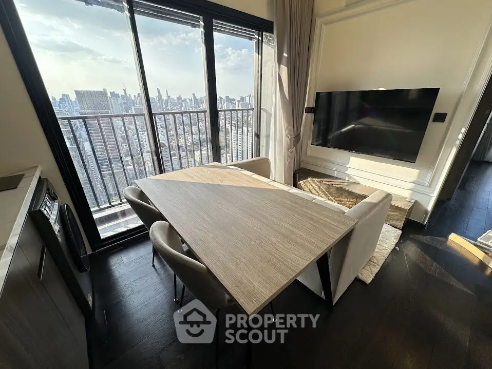 Modern living room with city view, featuring sleek furniture and large windows for natural light.