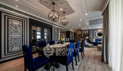 Luxurious dining and living area with elegant decor and plush blue seating.