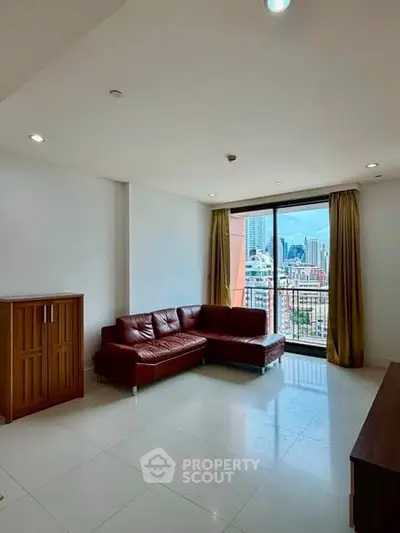Spacious living room with city view and modern leather sofa in high-rise apartment.