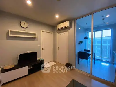 Modern living room with air conditioning and adjacent dining area with balcony view.