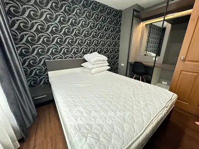 Modern bedroom with stylish wallpaper and cozy bed in a contemporary apartment.