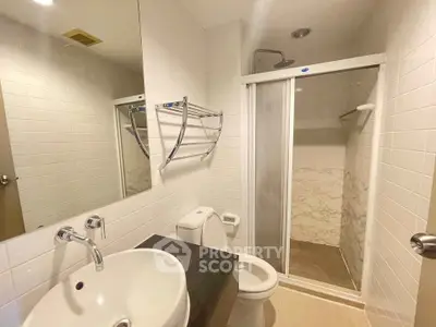 Modern bathroom with sleek fixtures and spacious shower in a contemporary apartment.
