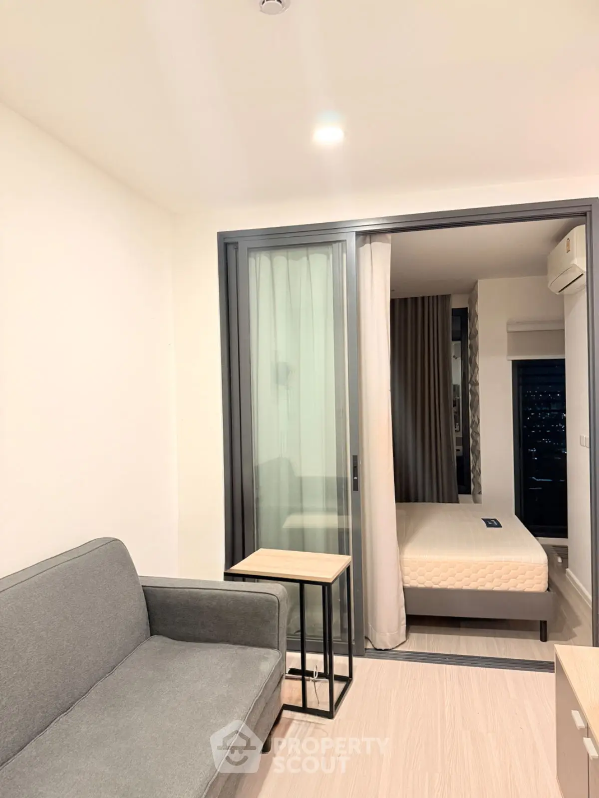 Modern apartment interior with cozy living area and bedroom view.