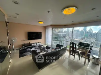 Spacious living room with panoramic city views and modern furnishings in a high-rise apartment.