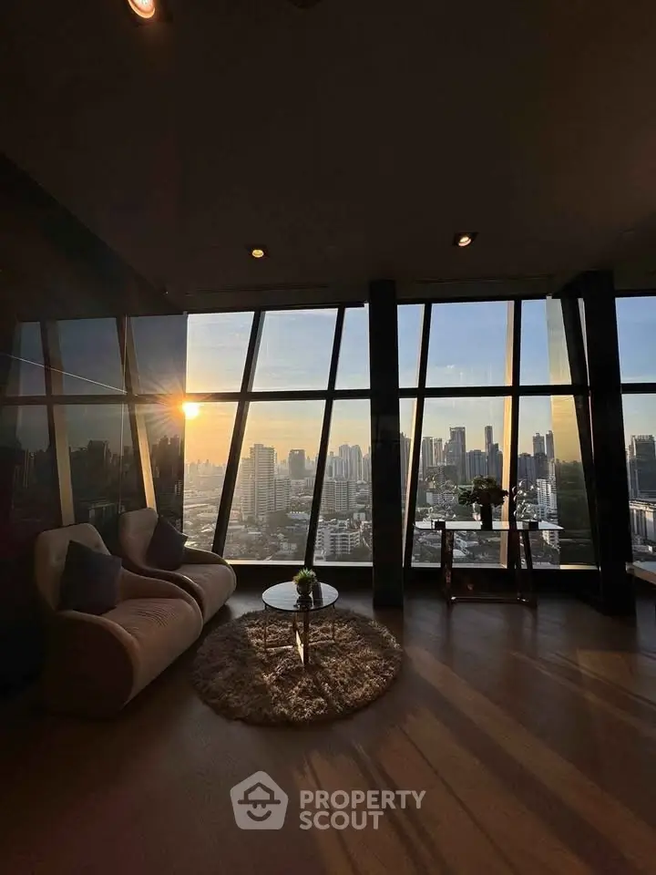 Luxurious high-rise living room with stunning city skyline view at sunset.