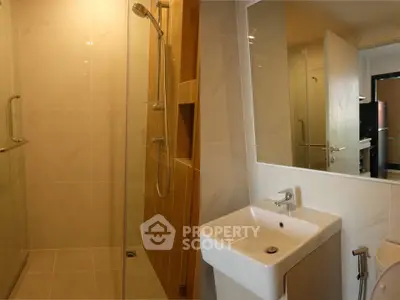Modern bathroom with sleek shower and stylish sink in contemporary apartment.