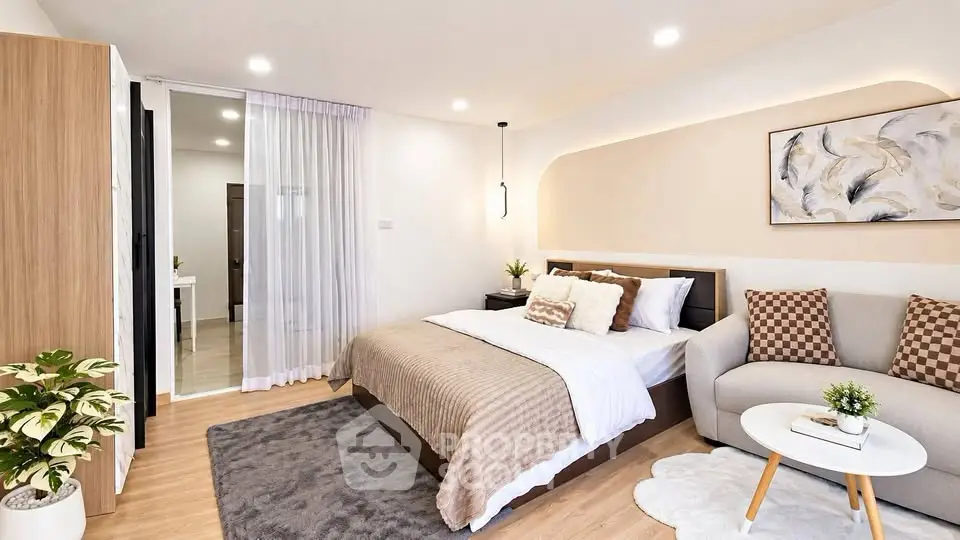 Modern bedroom with cozy decor, featuring a stylish bed, elegant sofa, and chic artwork, perfect for relaxation.