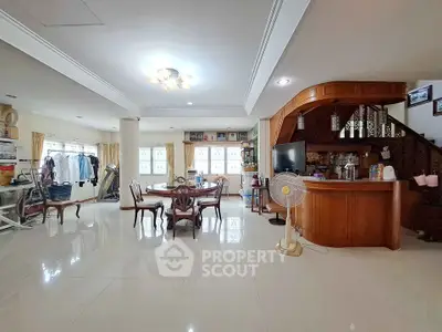 Spacious open-plan living room with elegant dining area and stylish staircase