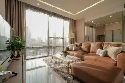 Luxurious living room with city view, elegant decor, and plush seating in modern apartment.