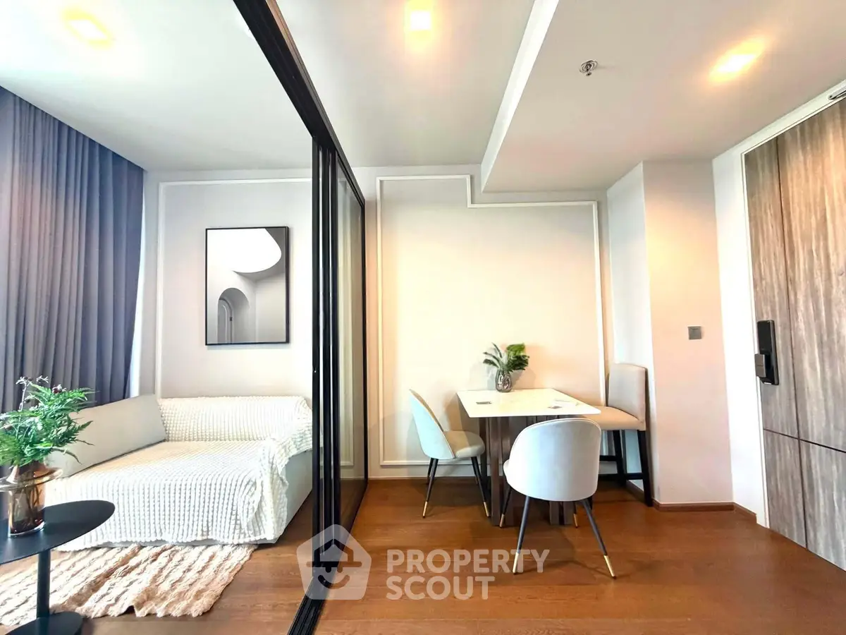 Modern living room with stylish dining area and cozy seating, featuring elegant decor and natural light.