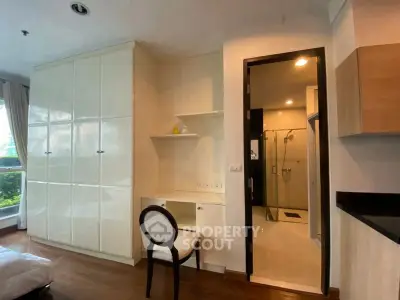 Modern bedroom with built-in wardrobe and ensuite bathroom in a stylish apartment.