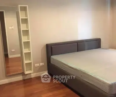 Spacious bedroom with modern bed and wooden flooring, ideal for comfort and relaxation.