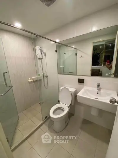 Modern bathroom with glass shower enclosure and sleek fixtures in a contemporary home.
