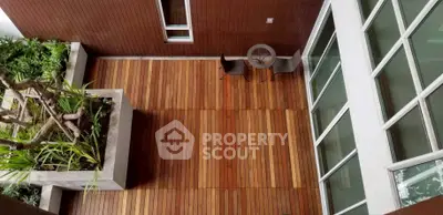 Stunning wooden deck with modern seating and lush greenery, perfect for relaxation and outdoor gatherings.