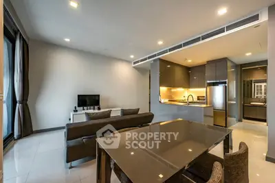 Modern open-plan living room and kitchen with sleek design and ample natural light.