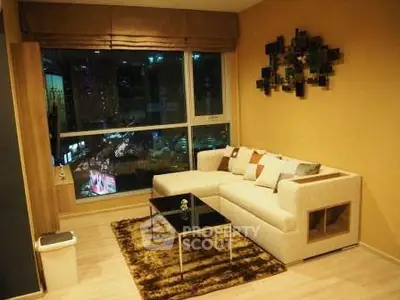 Stylish living room with modern decor and city view, featuring a cozy sofa and elegant wall art.